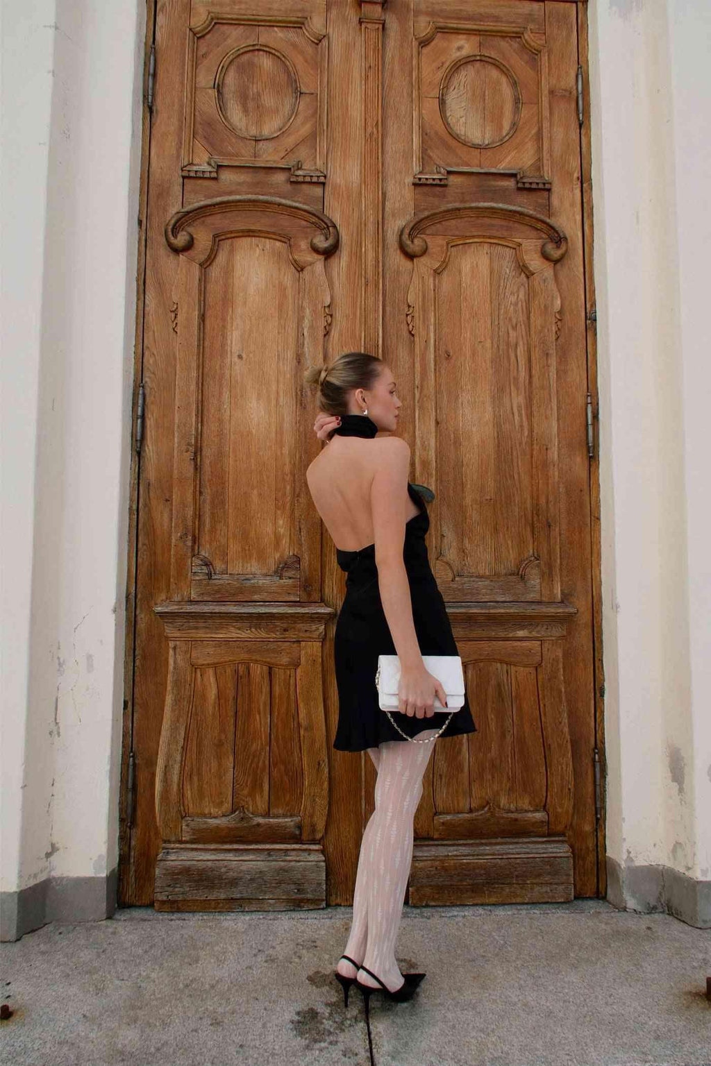 Black halter satin mini dress back view with open-back neckline and V-shaped upper back