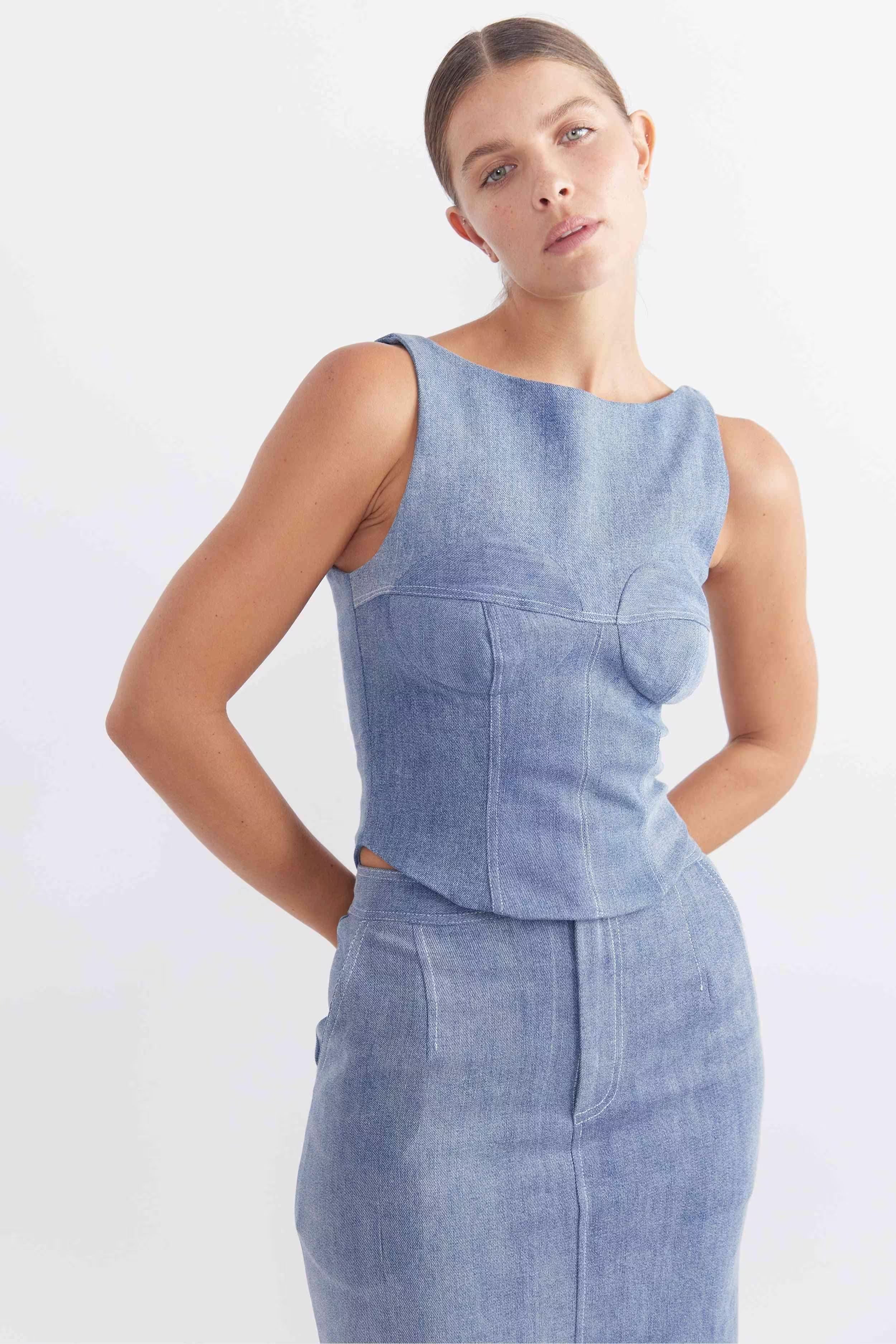 Sleeveless blue denim bodice close-up with curved front seams and peplum waist