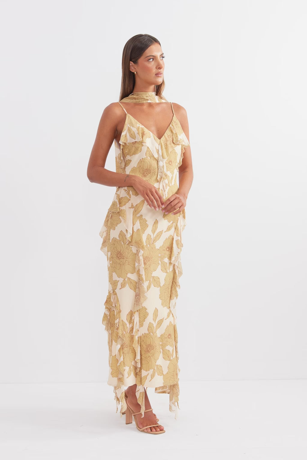 Golden midi dress with spaghetti straps and layered ruffle hem, side profile