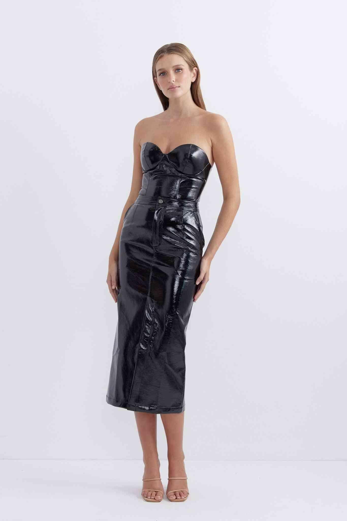 Glossy patent black fitted midi skirt with seam detailing and front slit