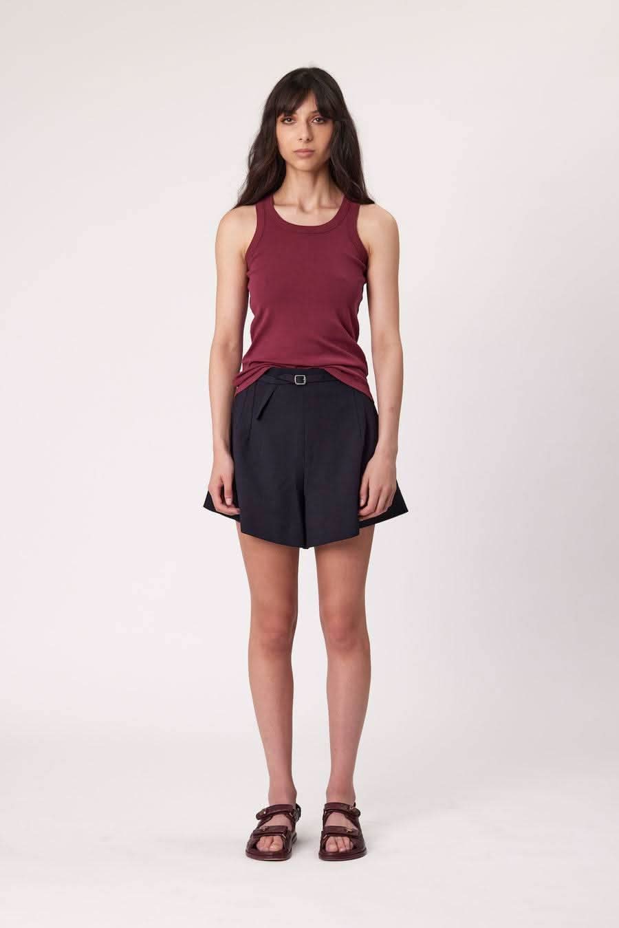Dark tailored shorts with cuffed hem and belt detail at waist