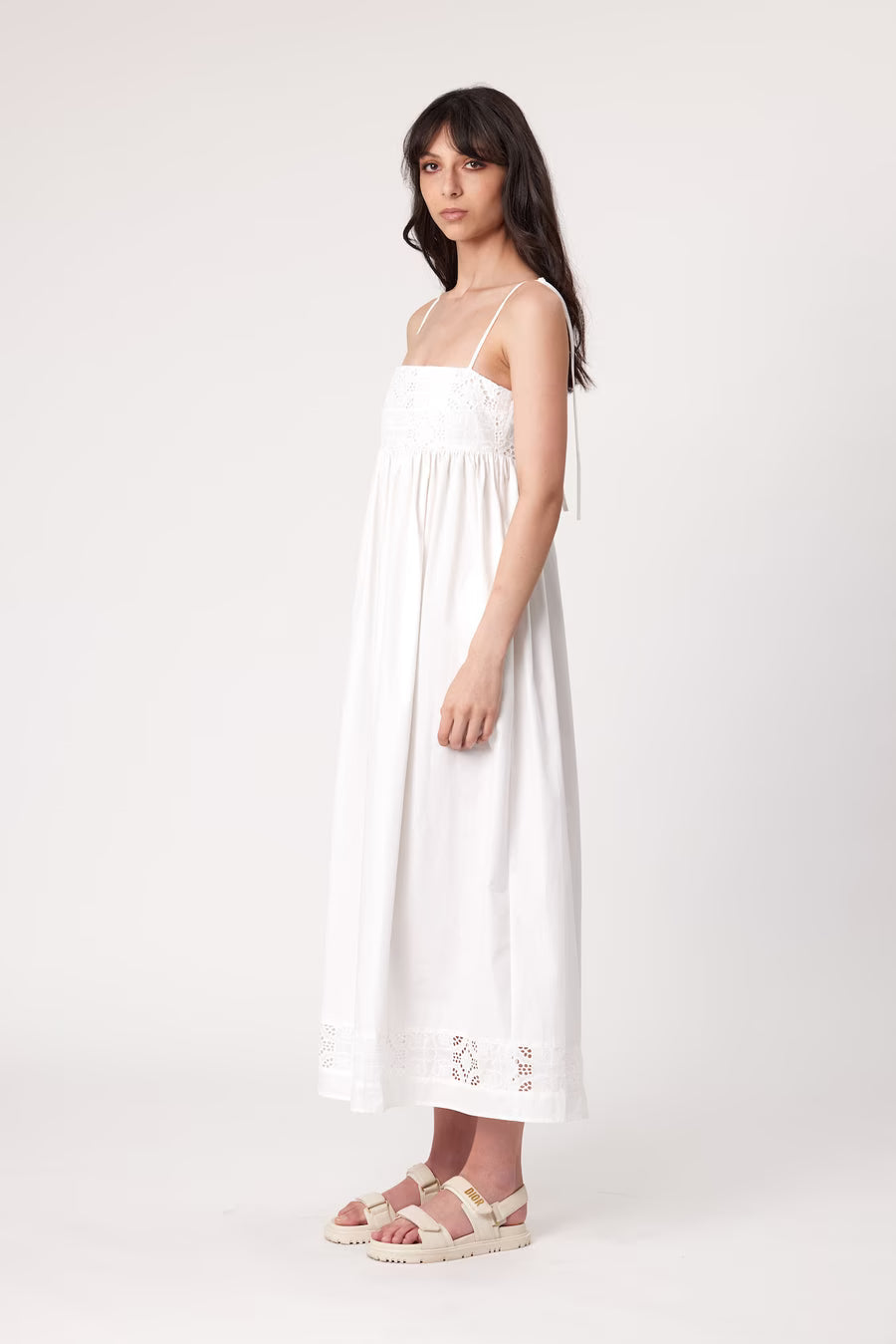 Ivory maxi dress, side view, with spaghetti straps and embroidered lace hem