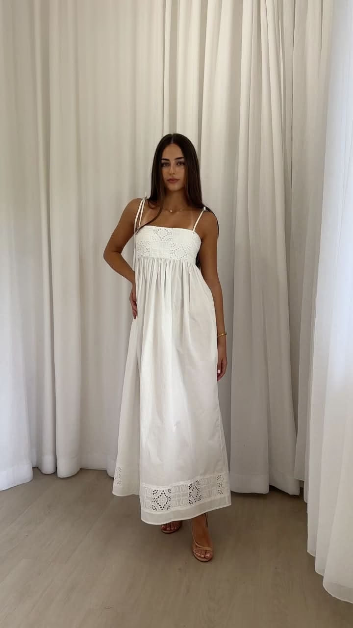 Ivory maxi dress with spaghetti straps and gathered skirt with lace border hem