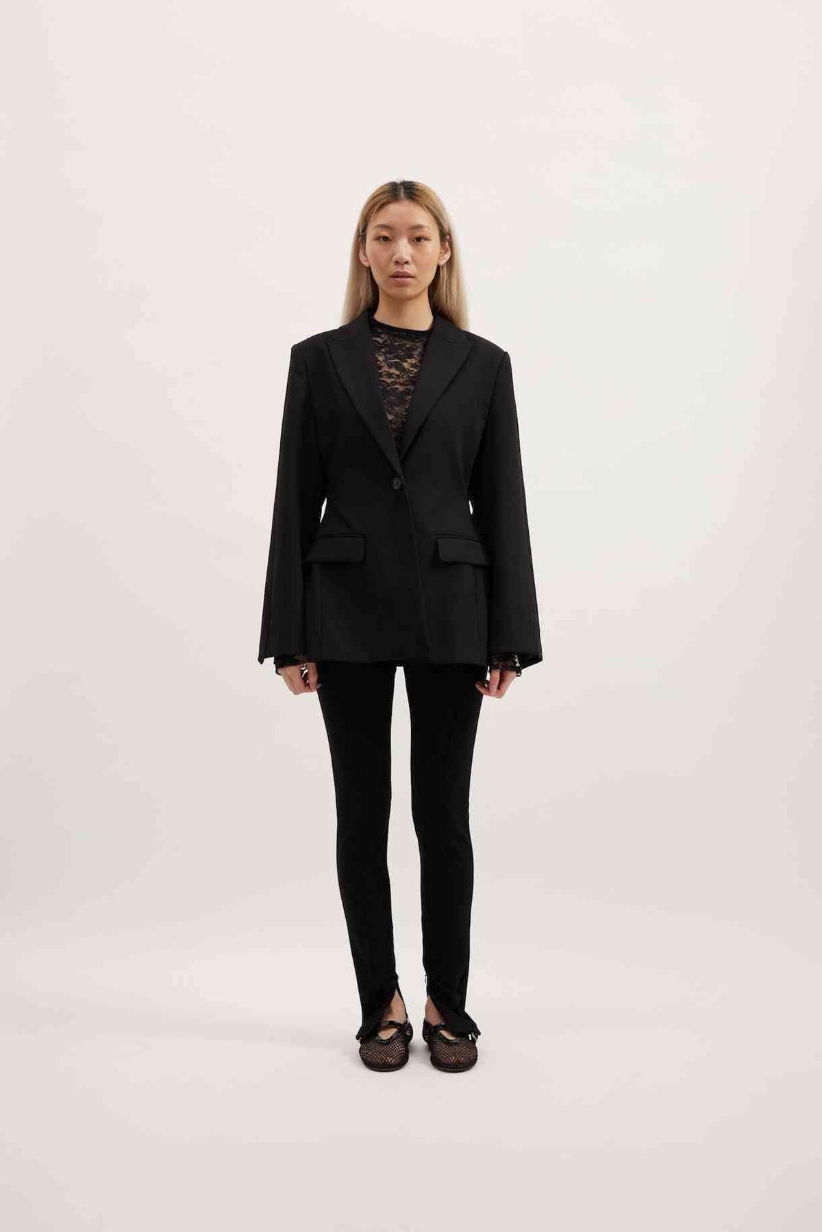 Black Sofia blazer with notch lapels and flap pockets, shown with long sleeves