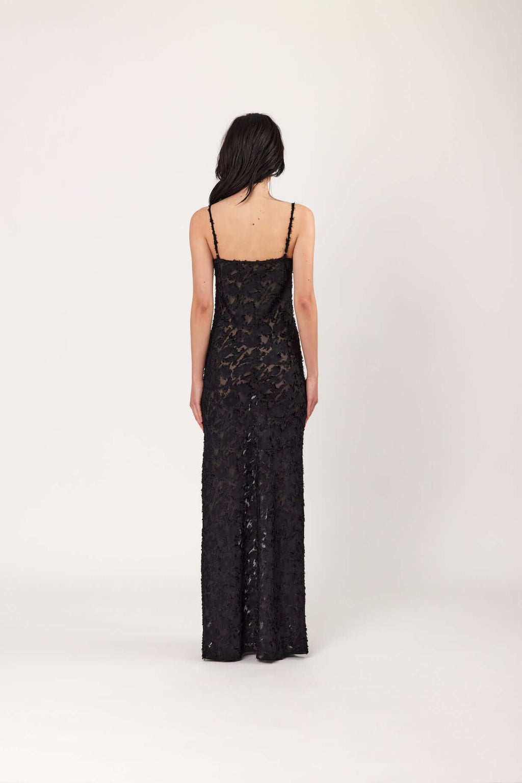 Back view of black lace slip dress with spaghetti straps, full-length fitted maxi