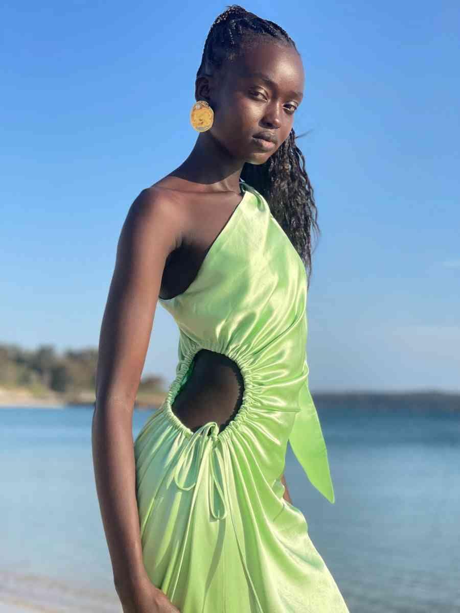 Light green halter maxi dress with oval waist cutout, draped ruching, and long skirt.