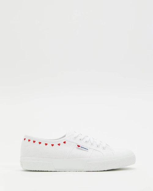 White lace-up sneakers with red heart embroidery along the front collar