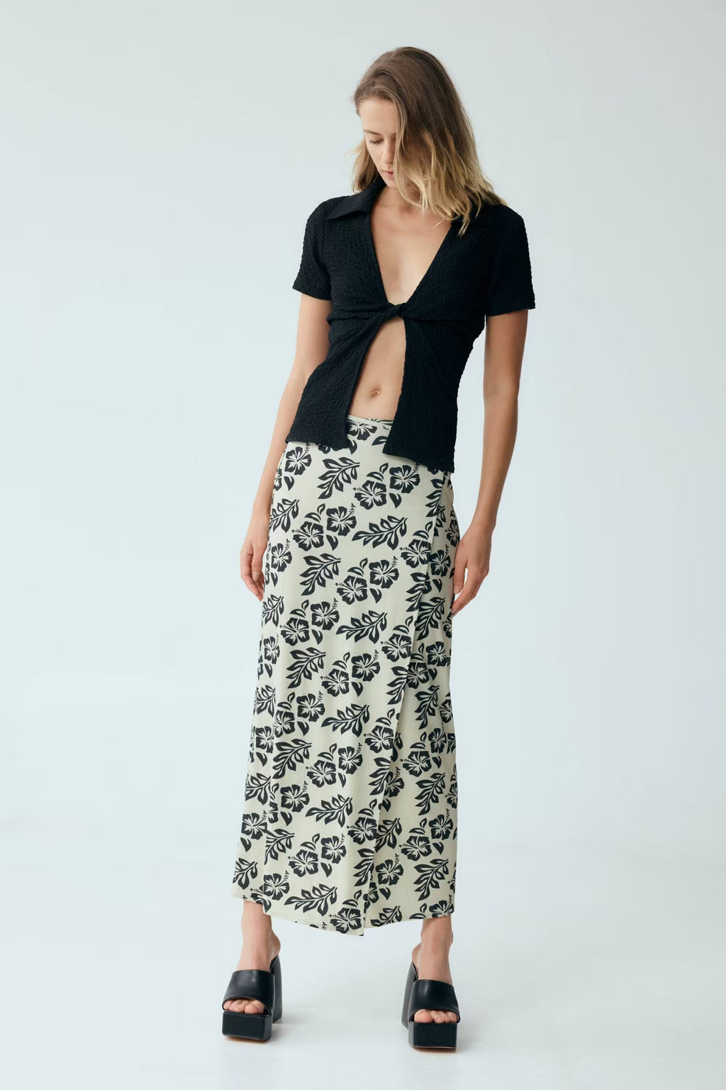 Black waffle twist V-neck short-sleeve shirt with knotted front cutout.