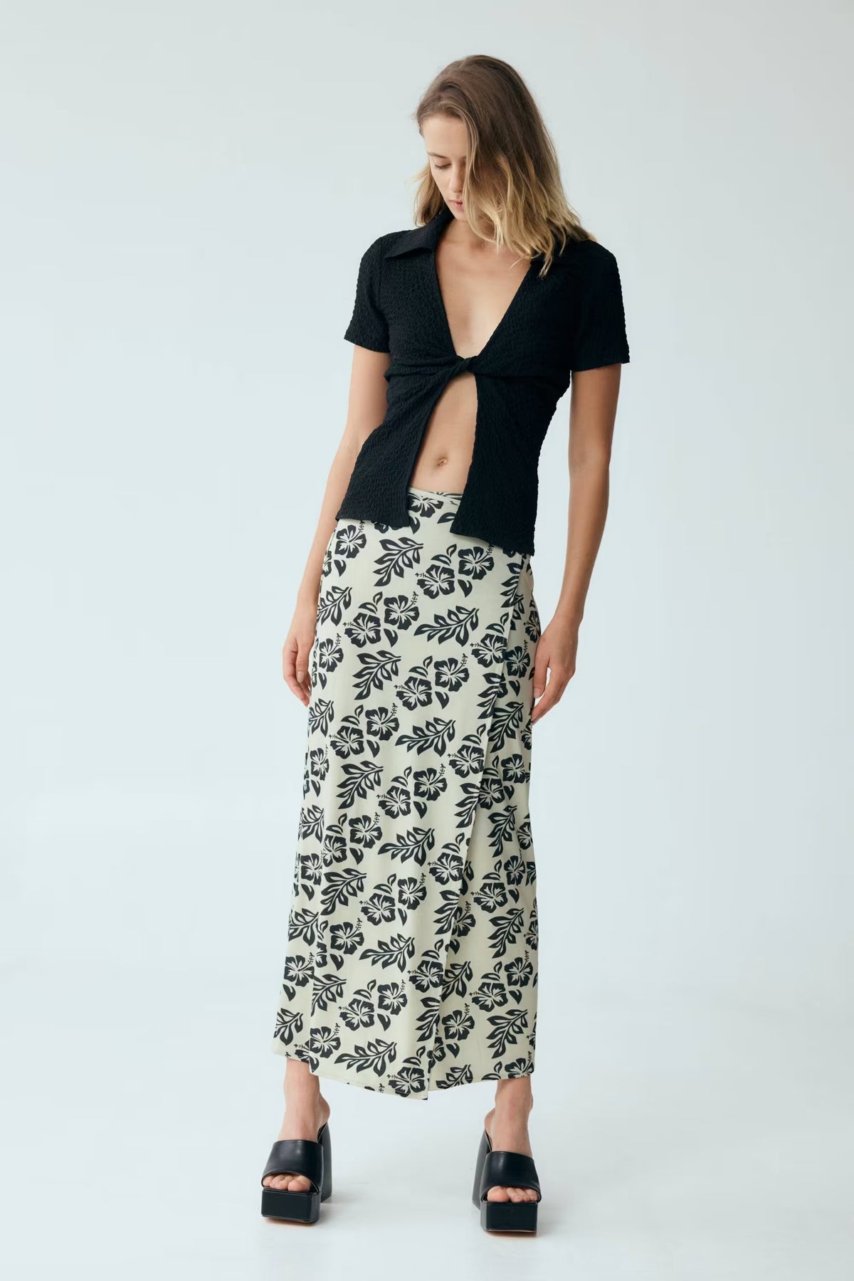 Black waffle twist V-neck short-sleeve shirt with knotted front cutout.