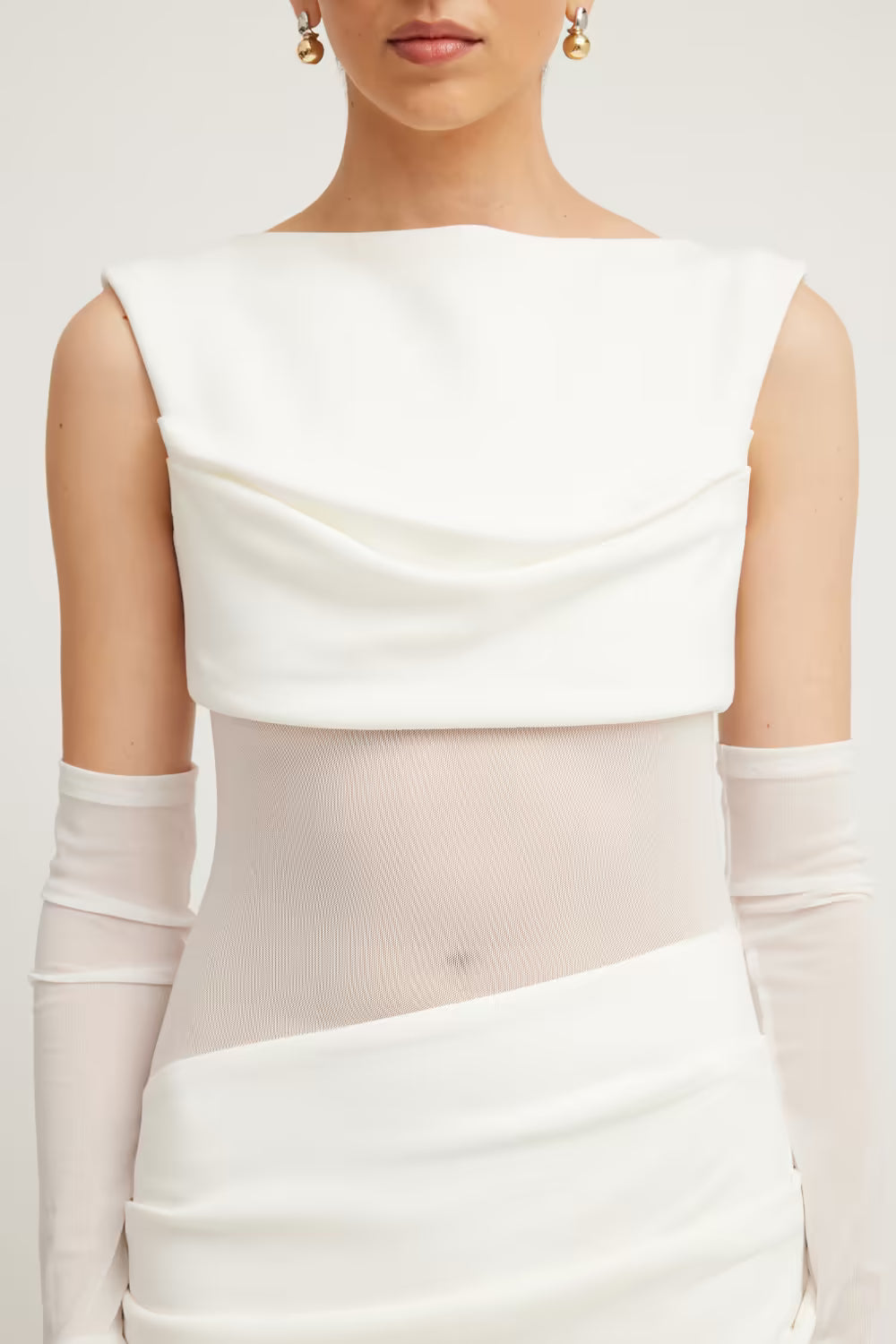 Ivory sleeveless dress close-up with draped neckline and mesh waist panel