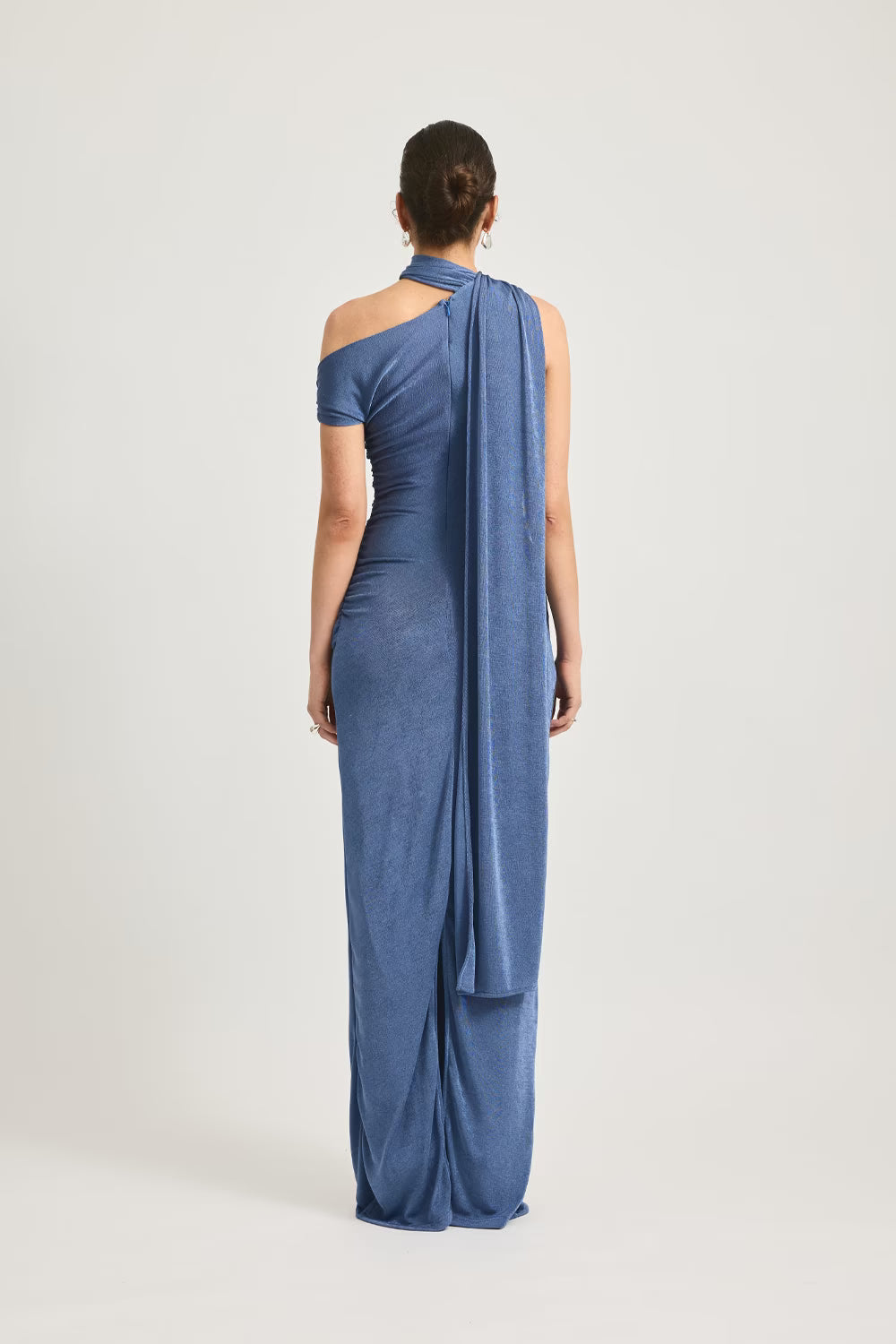 Back view of blue one-shoulder maxi dress with draped shoulder and flowing back panel