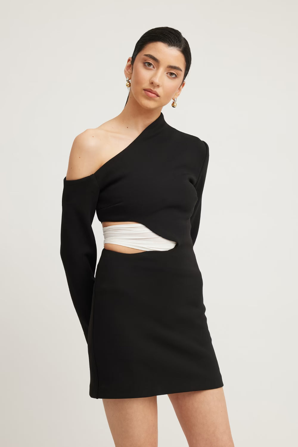Black one-shoulder mini dress with long sleeves and white asymmetric cutout