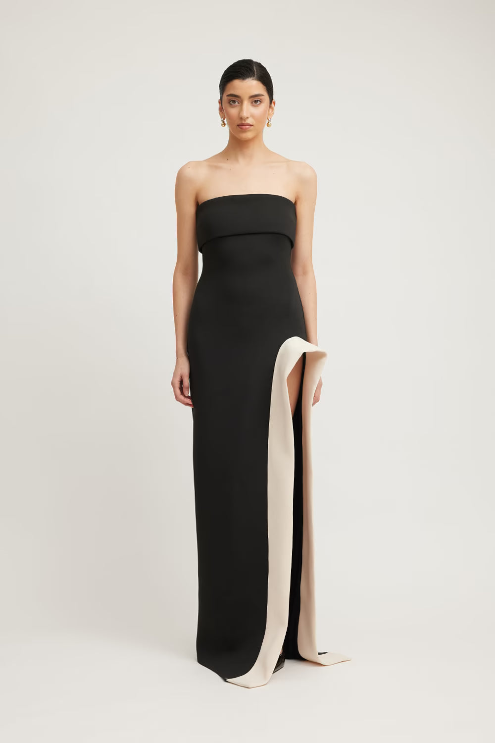 Black strapless column dress with side slit and champagne contrast lining