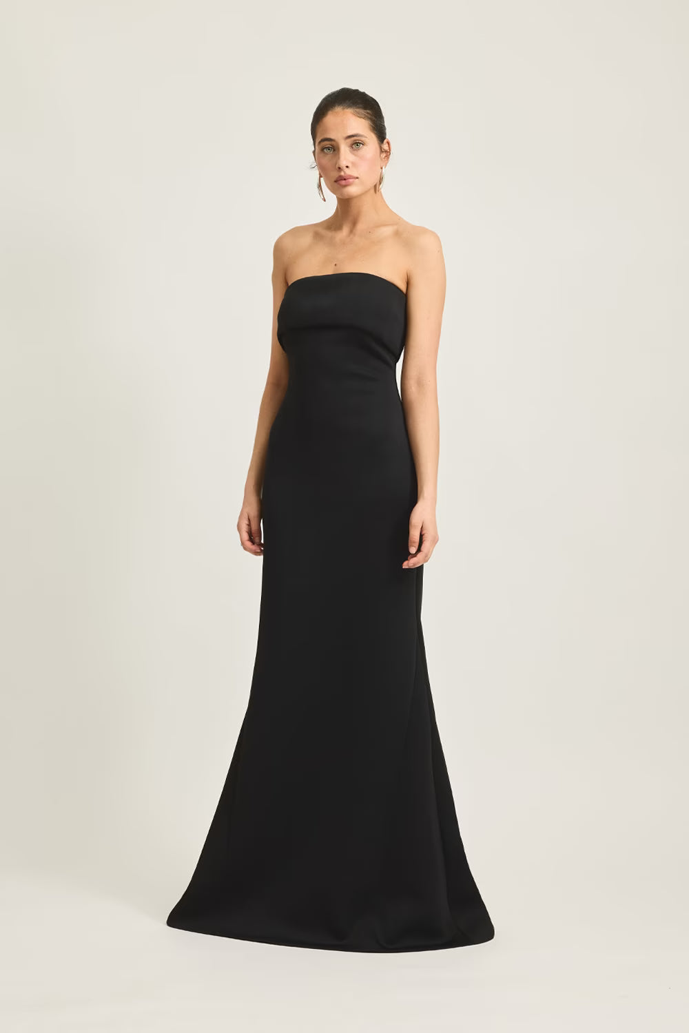 Black strapless evening gown with fitted silhouette and long flowing skirt.