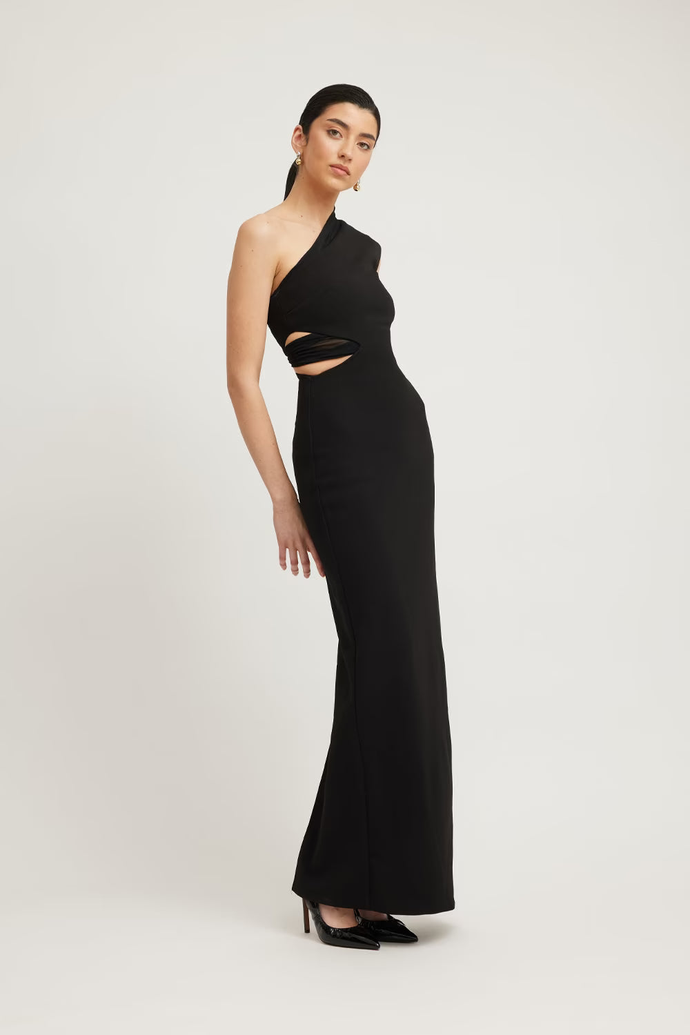 Black one-shoulder column dress with diagonal side cutout at the waist