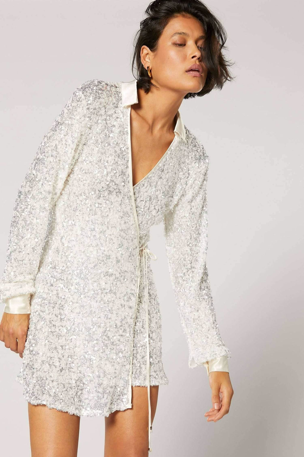 White speckled wrap shirt close-up with V neckline and long sleeves.