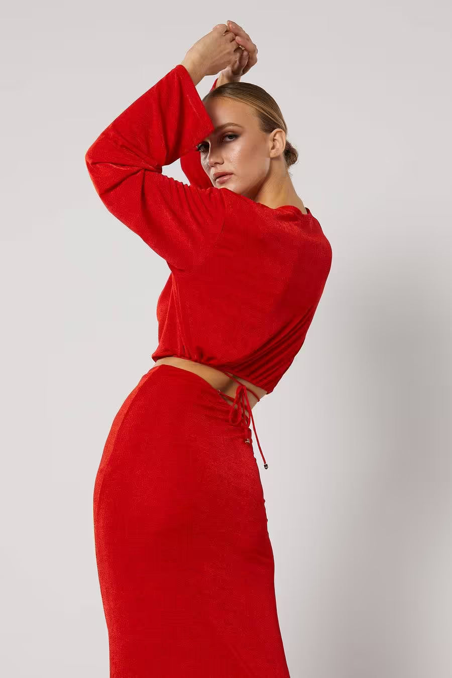 Red long-sleeve wrap top with deep V neckline and tied waist cutout