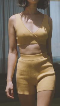 a woman in a yellow Bare by Charlie Holiday The Crop Top and shorts