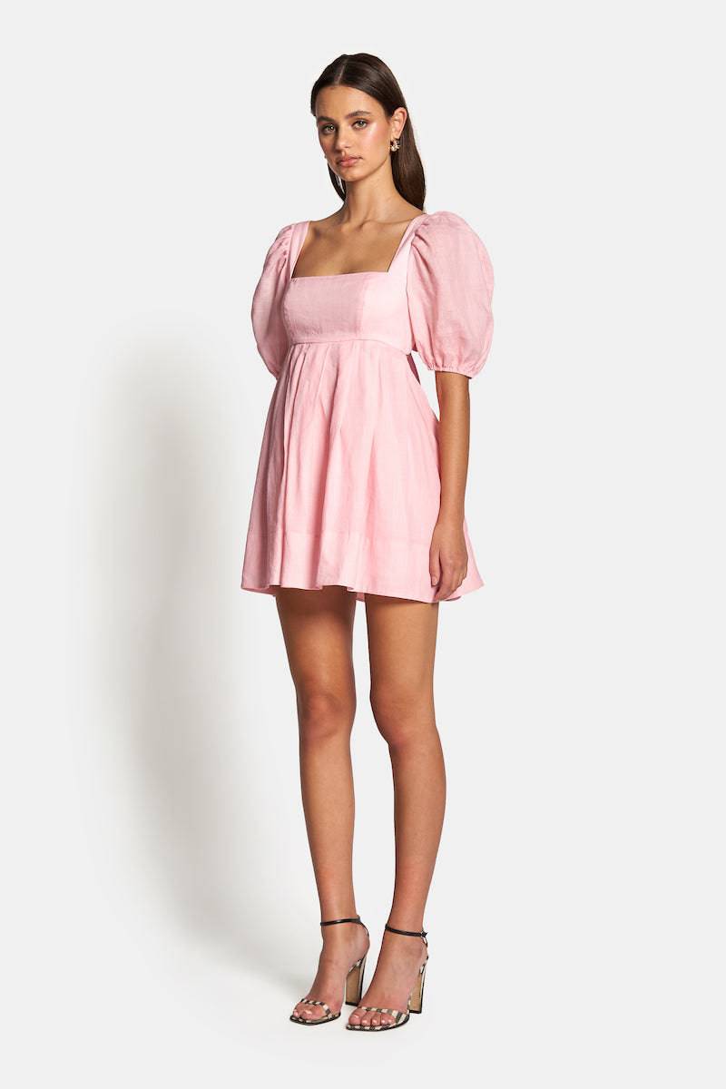 a woman wearing a pink Sofia The Label Aerin Open Back Tie Mini Dress and sandals