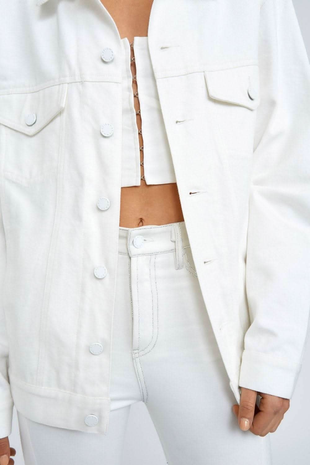 White denim jacket close-up: snap buttons and chest patch pockets