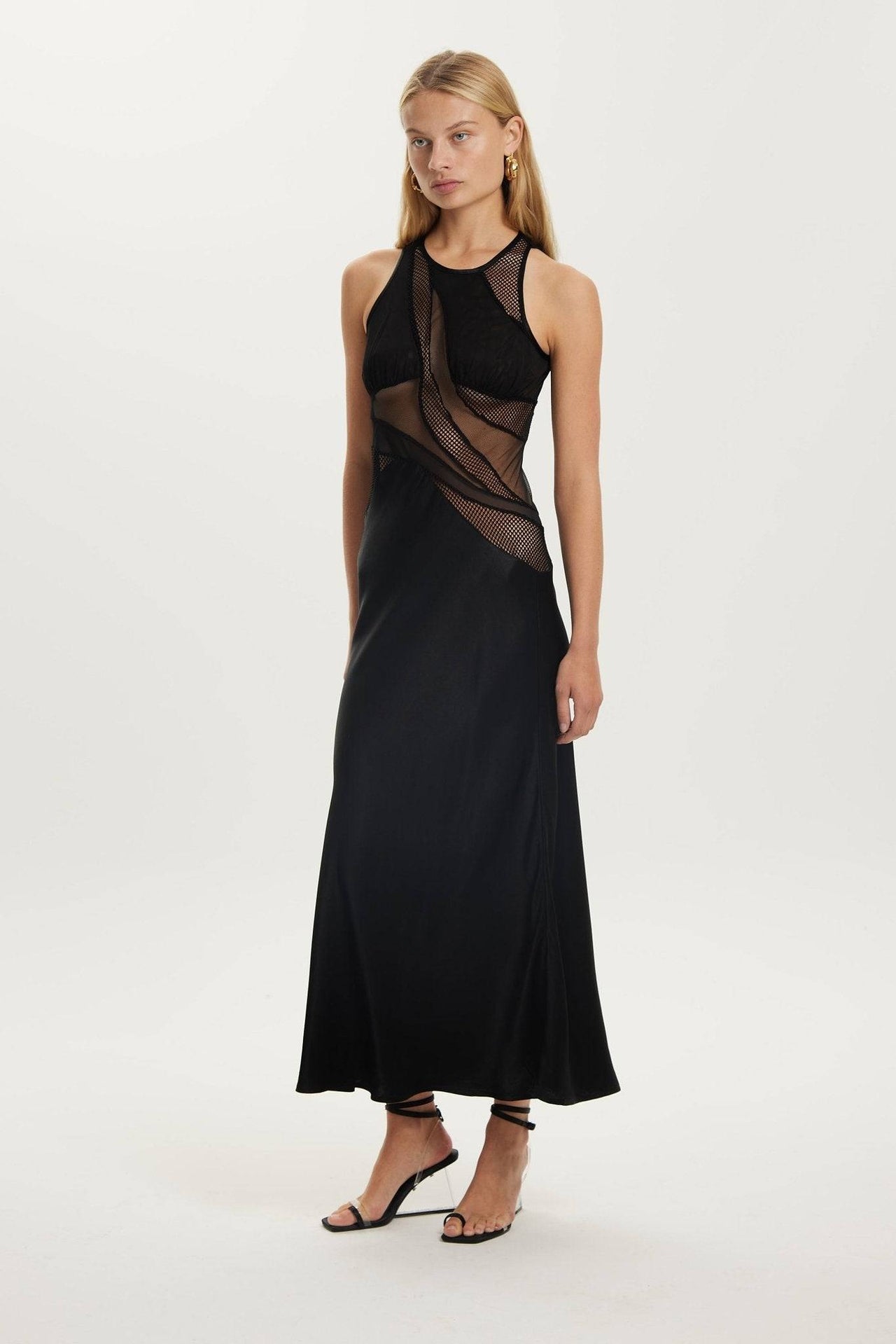 a woman wearing a black Third Form Crystal Clear Maxi Tank Dress and sandals