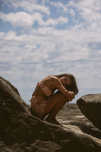 Thumbnail for a woman sitting on top of a rock near the ocean